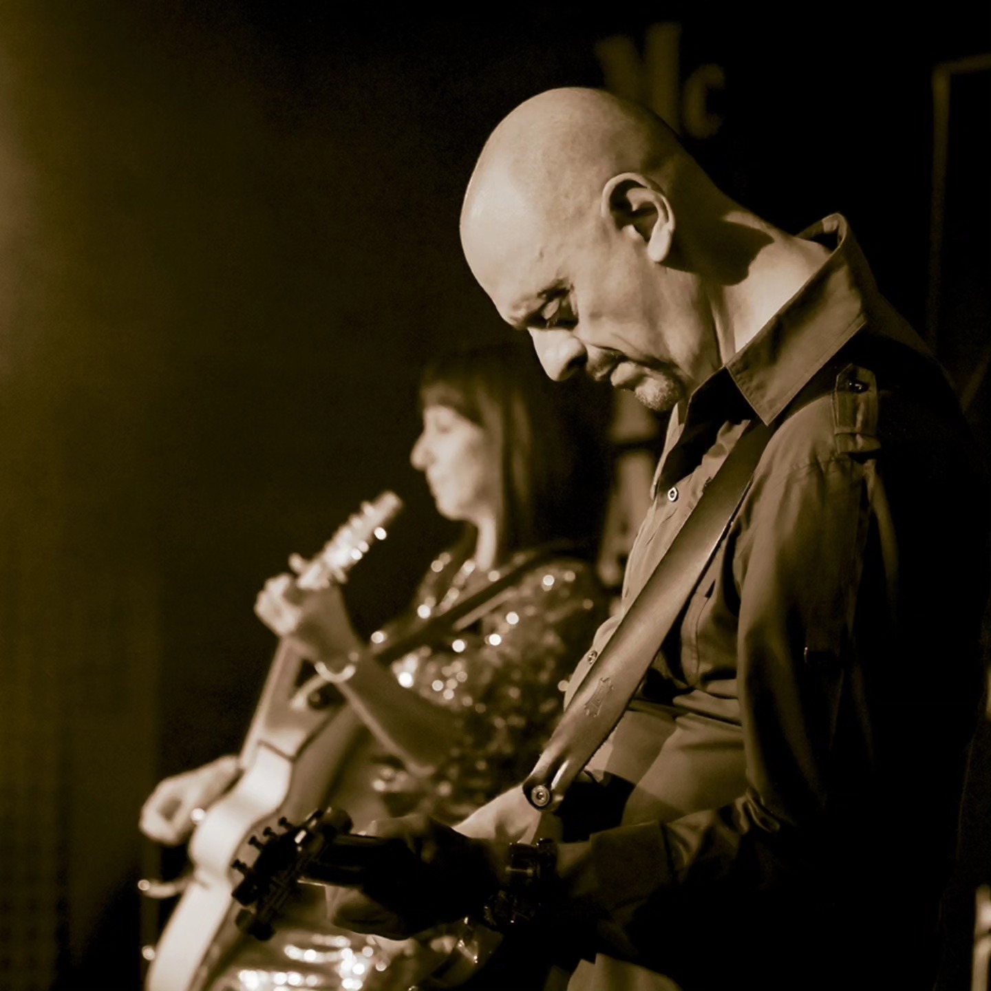 Sepia live detail with guitar in foreground
